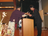 感謝状と記念品を受取り、感激？し幹事に握手を求める篠田会長